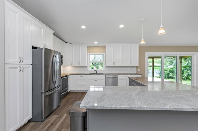 kitchen with stainless steel appliances, sink, light stone countertops, white cabinets, and dark wood-type flooring