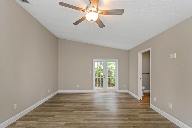 spare room with french doors, a textured ceiling, vaulted ceiling, dark wood-type flooring, and ceiling fan