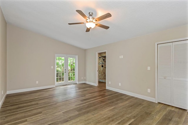 empty room featuring french doors, vaulted ceiling, a textured ceiling, dark hardwood / wood-style floors, and ceiling fan