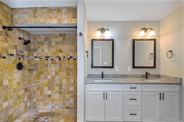 bathroom with tiled shower and vanity