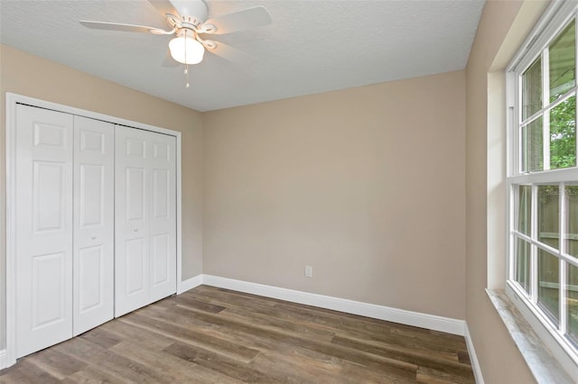 unfurnished bedroom with hardwood / wood-style floors, ceiling fan, a textured ceiling, and a closet