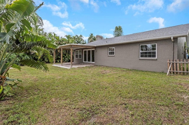 rear view of house with a lawn and a patio