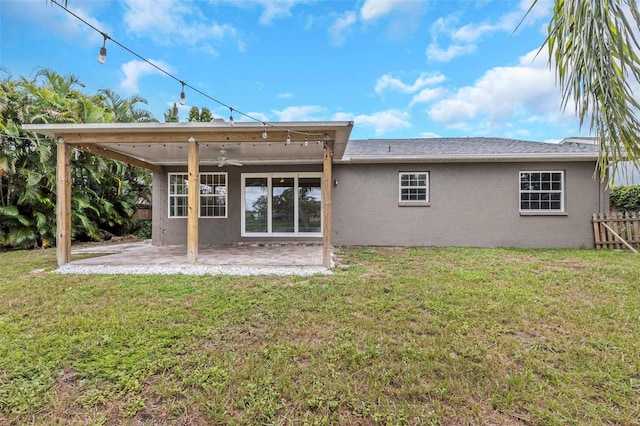 back of property featuring ceiling fan, a lawn, and a patio