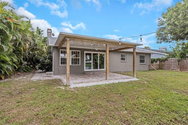 back of house featuring a patio area and a lawn