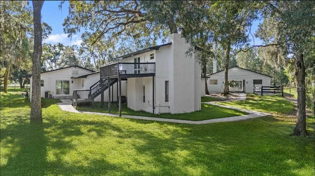 rear view of house featuring a yard and a deck