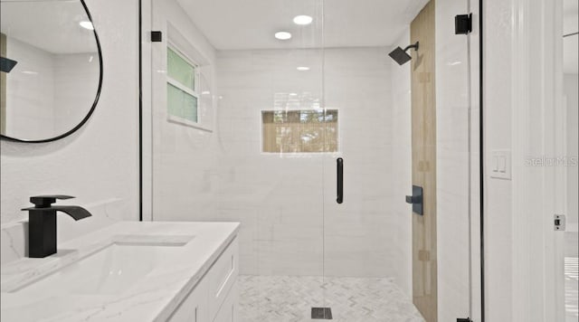 bathroom featuring vanity and a shower with door