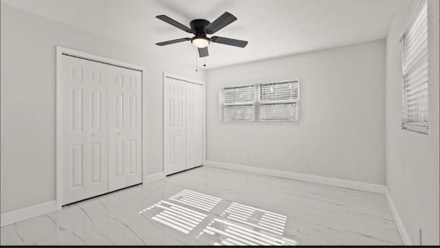 unfurnished bedroom featuring two closets and ceiling fan