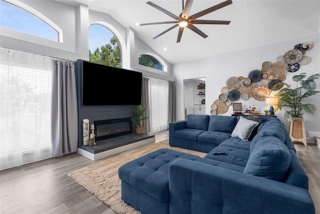 living room with ceiling fan, hardwood / wood-style floors, and high vaulted ceiling