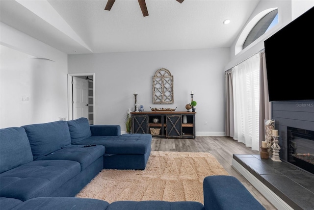 living room with ceiling fan, lofted ceiling, and hardwood / wood-style floors