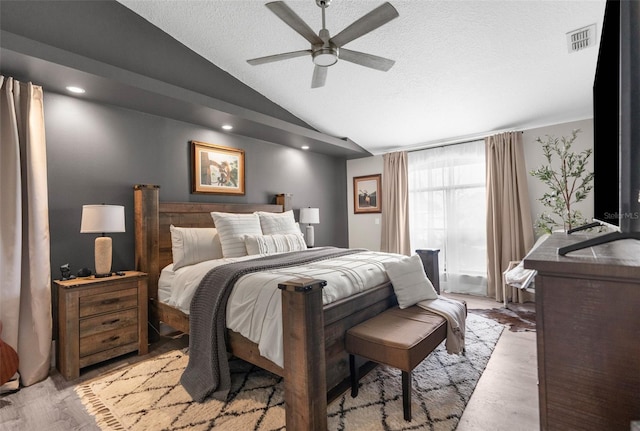 bedroom featuring ceiling fan, a textured ceiling, light hardwood / wood-style flooring, and vaulted ceiling