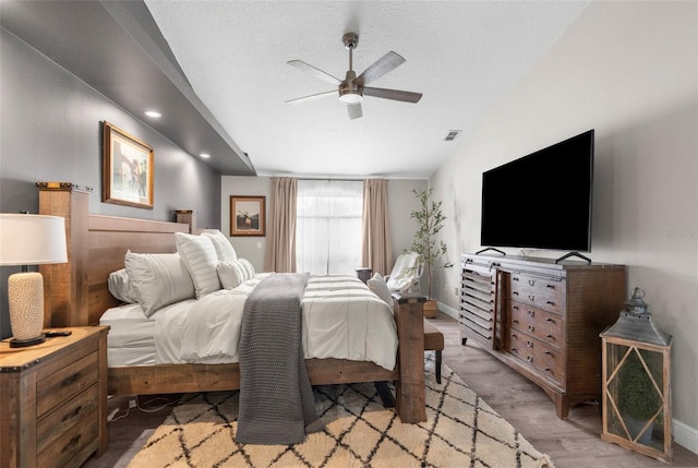 bedroom featuring ceiling fan, a textured ceiling, lofted ceiling, and hardwood / wood-style floors