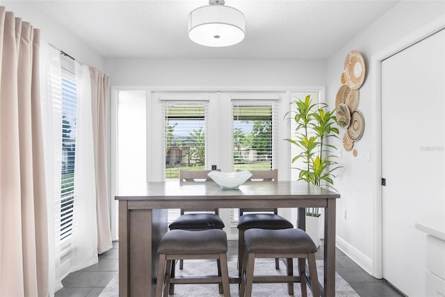 tiled dining area with a textured ceiling