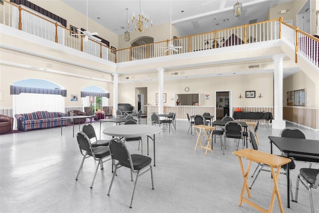 dining room with a notable chandelier, a high ceiling, and ornate columns