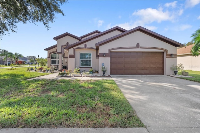 view of front facade with stucco siding, driveway, a front yard, and a garage