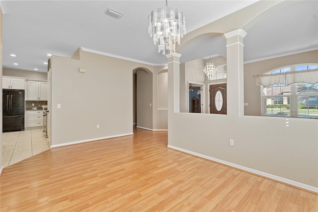 unfurnished living room featuring ornate columns, visible vents, ornamental molding, light wood-style floors, and baseboards