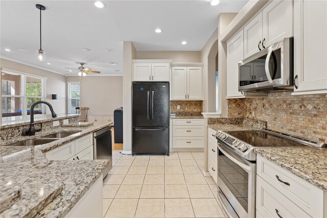 kitchen with sink, black appliances, white cabinetry, and hanging light fixtures