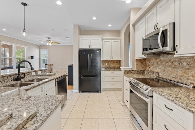 kitchen featuring stainless steel appliances, a sink, white cabinetry, a ceiling fan, and hanging light fixtures