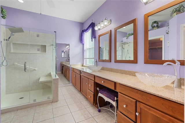 bathroom with a shower with door, vanity, and tile patterned floors