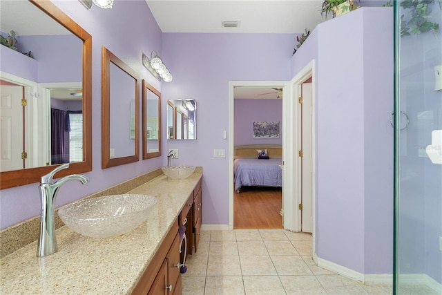 ensuite bathroom with a sink, double vanity, ensuite bath, tile patterned flooring, and visible vents