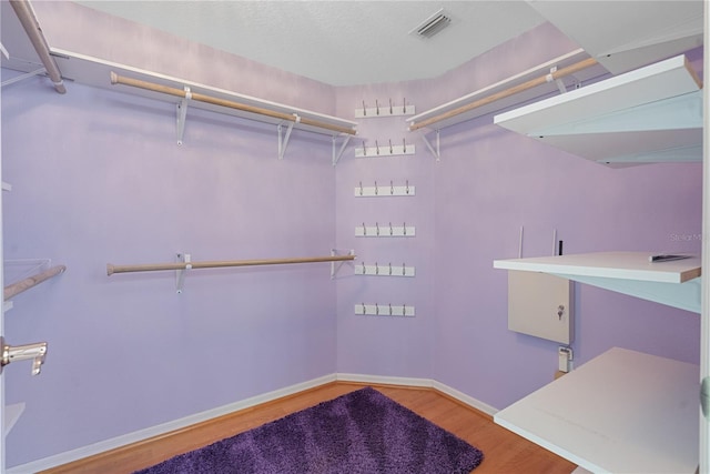 walk in closet featuring wood finished floors and visible vents