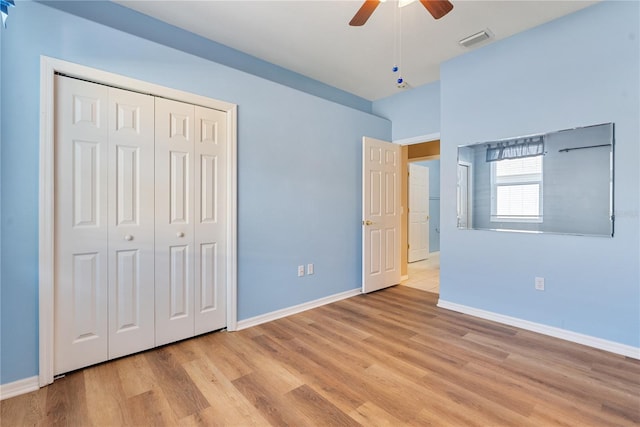 unfurnished bedroom with light wood-type flooring, baseboards, visible vents, and a closet