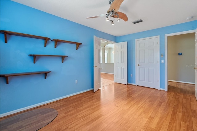 unfurnished bedroom with baseboards, a ceiling fan, visible vents, and light wood-style floors