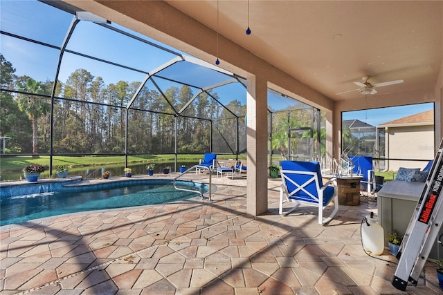 pool featuring a patio area, a ceiling fan, and glass enclosure