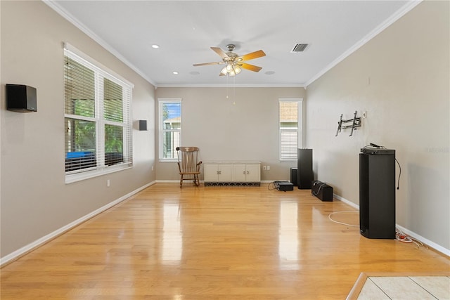 interior space featuring baseboards, a ceiling fan, crown molding, and light wood finished floors