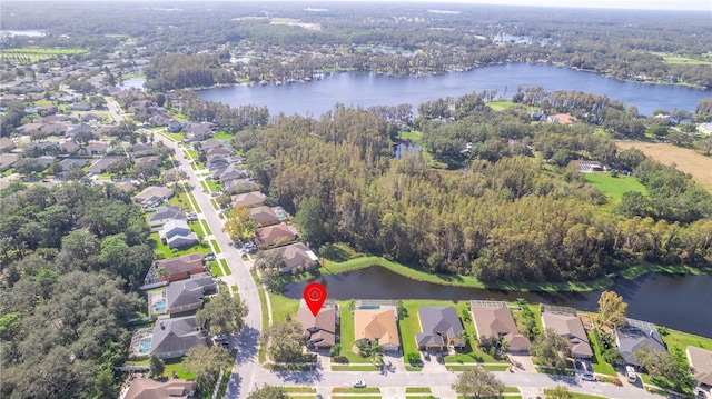 drone / aerial view with a residential view, a forest view, and a water view
