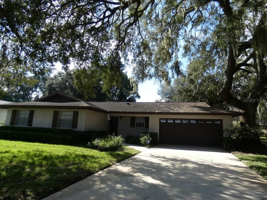 ranch-style house featuring a garage and a front lawn