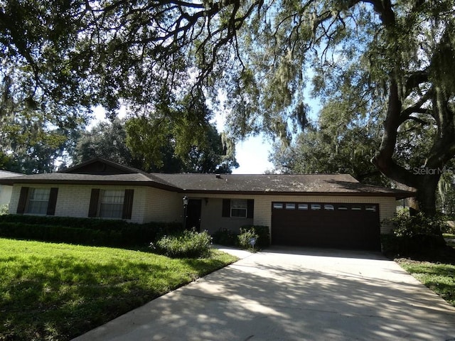 ranch-style house featuring a garage and a front lawn