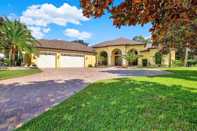 mediterranean / spanish home with a front yard and a garage