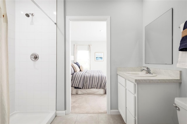 bathroom with a tile shower, tile patterned flooring, vanity, and toilet