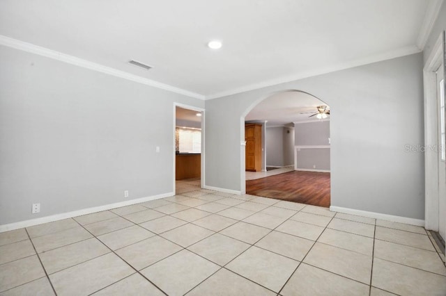 empty room featuring light tile patterned floors, ceiling fan, and crown molding