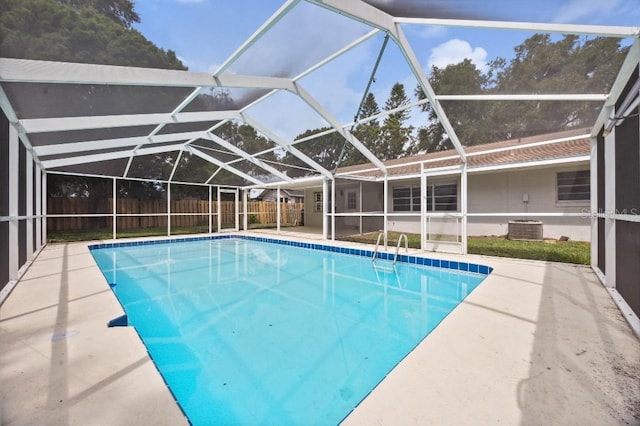 view of swimming pool featuring glass enclosure and a patio