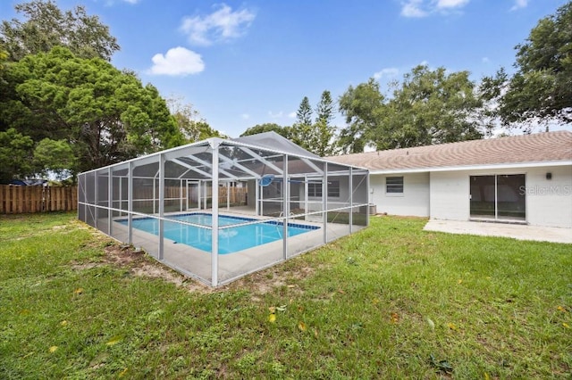 view of pool with a yard and glass enclosure