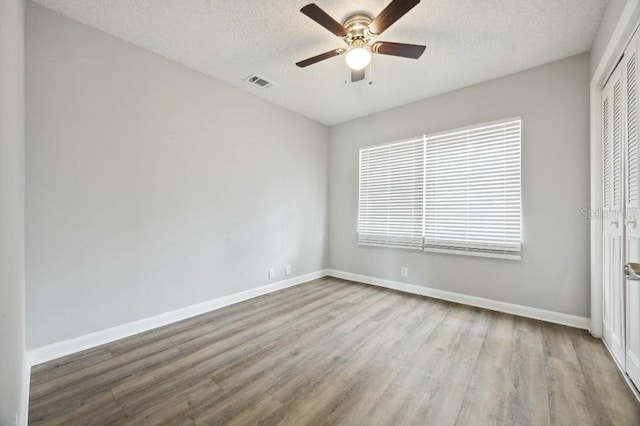 unfurnished bedroom with light wood-type flooring, a textured ceiling, and ceiling fan