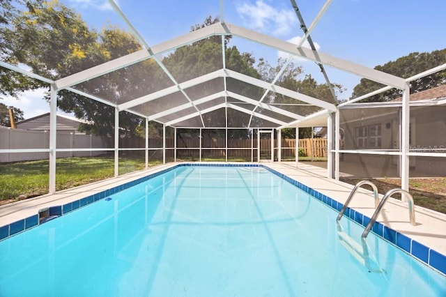 view of pool with a patio, a yard, and glass enclosure