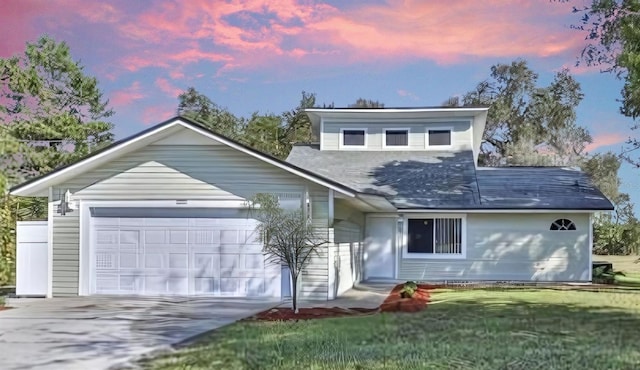 view of property with a garage and a lawn