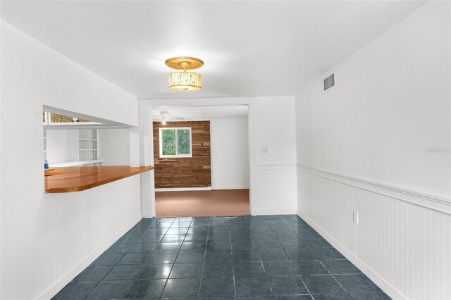 10221 Elgin Blvd, Spring Hill, FL 34608 - tiled spare room featuring wainscoting and ceiling fan