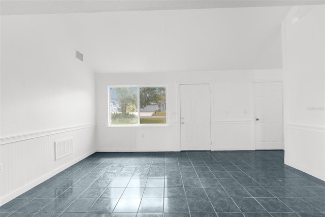 10221 Elgin Blvd, Spring Hill, FL 34608 - unfurnished room with wainscoting and lofted ceiling