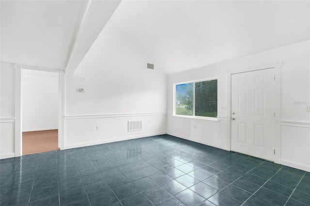 10221 Elgin Blvd, Spring Hill, FL 34608 - unfurnished living room featuring vaulted ceiling, dark tile patterned floors, and wainscoting