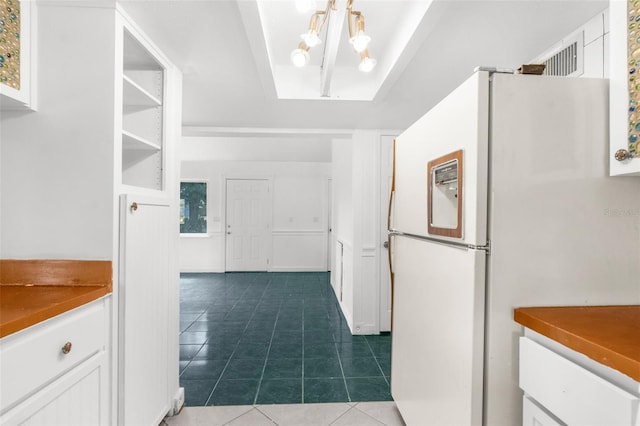 10221 Elgin Blvd, Spring Hill, FL 34608 - kitchen with freestanding refrigerator, white cabinetry, dark tile patterned floors, and a chandelier