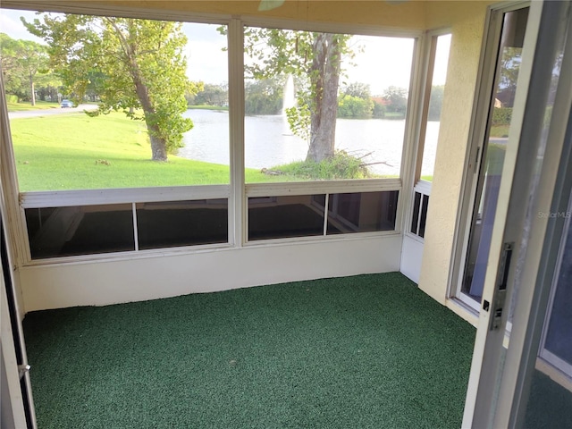 unfurnished sunroom featuring a water view