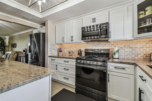 1847 Shore Dr S Unit 614, South Pasadena, FL 33707 - kitchen with tasteful backsplash, stainless steel appliances, white cabinets, ornamental molding, and visible vents