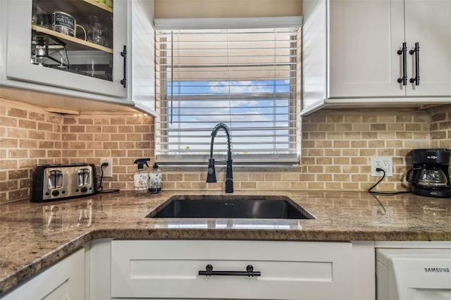 1847 Shore Dr S Unit 614, South Pasadena, FL 33707 - kitchen featuring dark stone countertops, a sink, white cabinetry, and tasteful backsplash