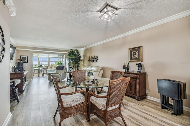 dining room with light wood-type flooring, crown molding, and a textured ceiling