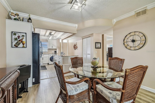 1847 Shore Dr S Unit 614, South Pasadena, FL 33707 - dining area with light wood-type flooring, visible vents, crown molding, and washer / clothes dryer