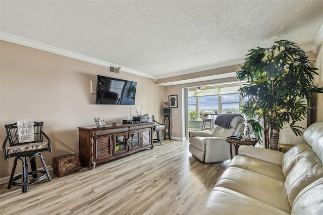 living room featuring light hardwood / wood-style flooring, a textured ceiling, ceiling fan, and crown molding