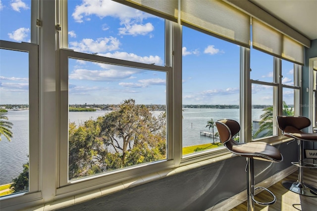 sunroom featuring a water view